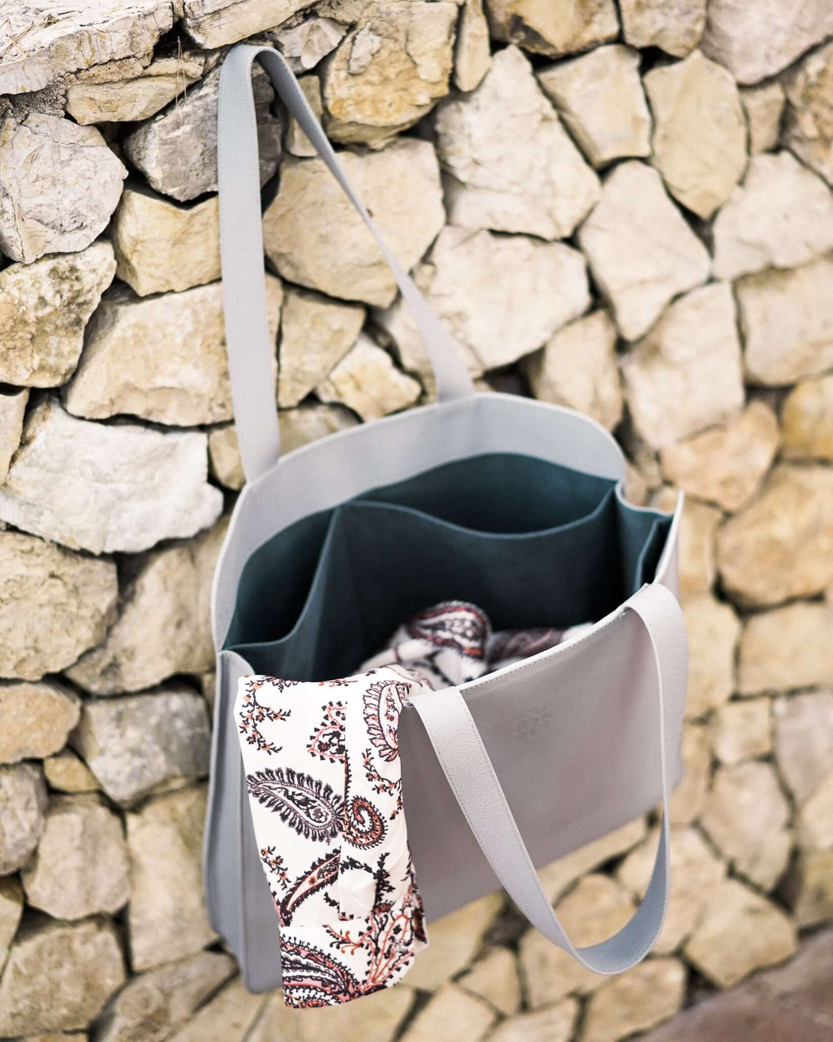 Elegant sea lavender leather laptop tote bag with paisley scarf, featuring wide straps and spacious pockets, ideal for professionals.